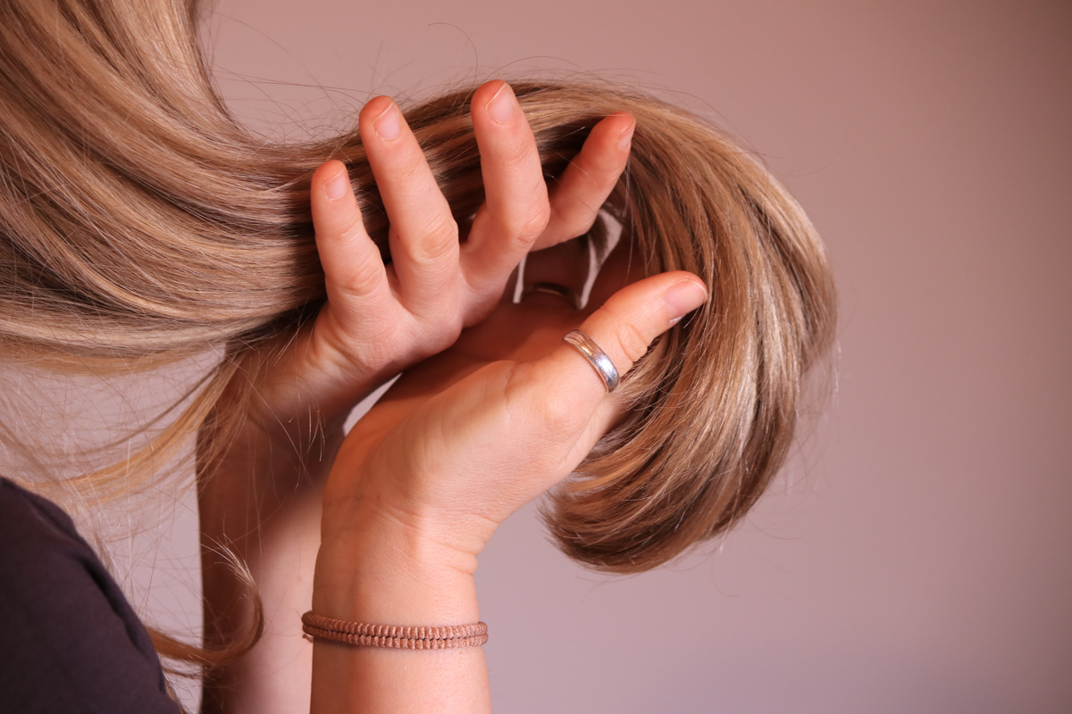 Young woman touching her blonde perfect hair